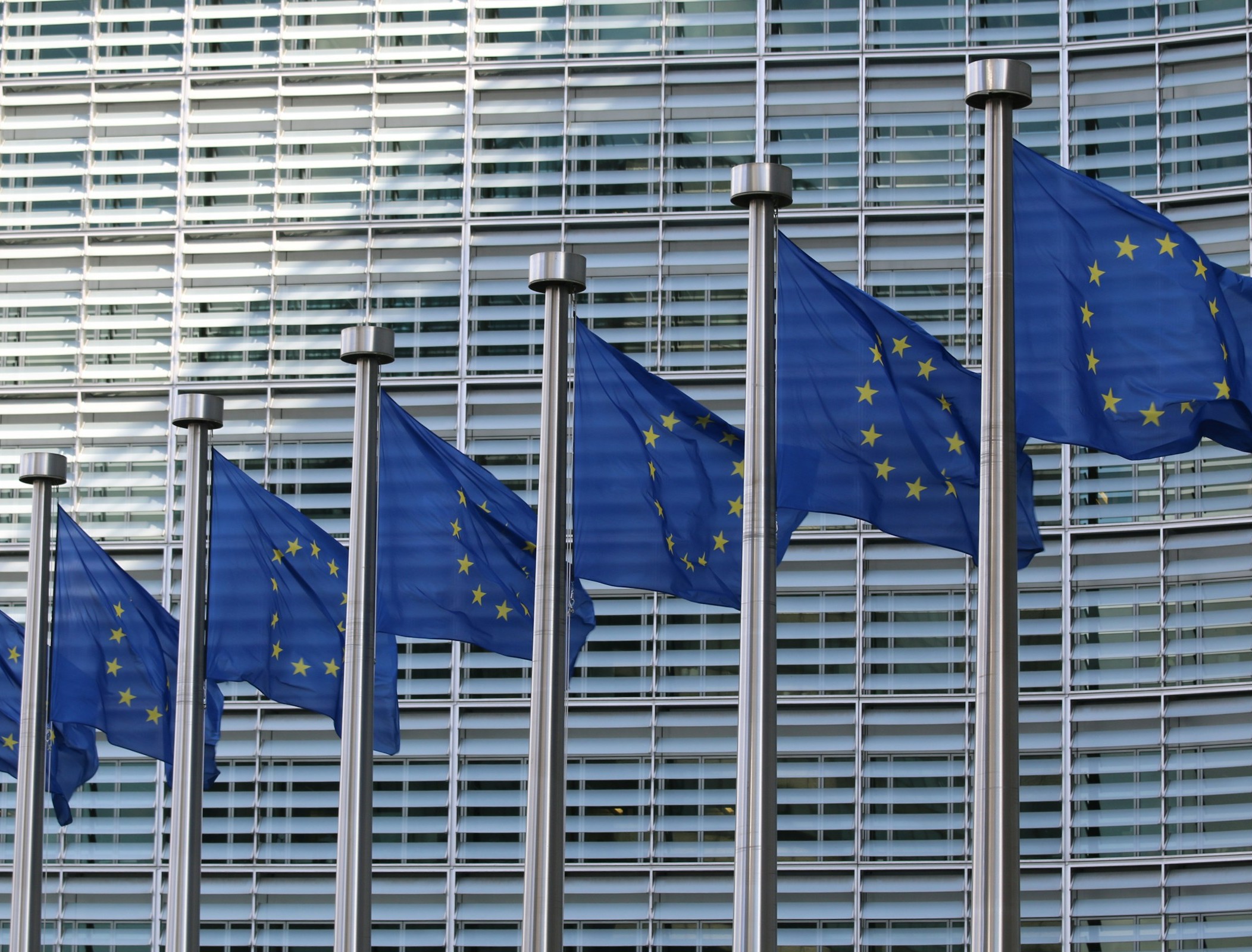 Flags of the European Union as the first regulations from the EU AI Act come into force with policies that set strict rules on how businesses use the technology for their operations and severe penalties for failures.